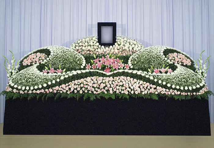 白とピンクの花を波のように配置した穏やかな雰囲気の祭壇。